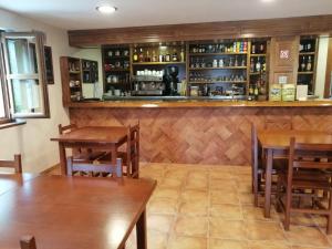布尔内斯El Caleyon的一间带木桌的餐厅和一间酒吧