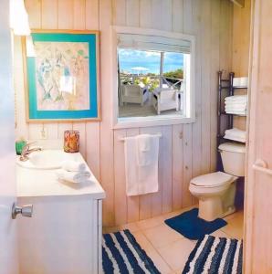 Staniel CaySea Smile的一间带卫生间、水槽和窗户的浴室