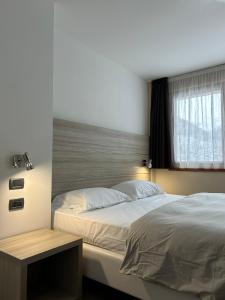 蓬泰迪莱尼奥乔利度假酒店及Spa的一间卧室设有一张大床和一个窗户。