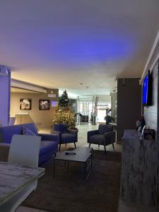 蓬泰迪莱尼奥乔利度假酒店及Spa的客厅配有蓝色的沙发和圣诞树