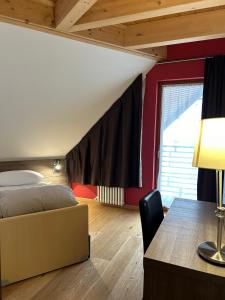 蓬泰迪莱尼奥乔利度假酒店及Spa的一间卧室配有一张床、一张桌子和一张桌子