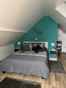 Sainte-Croix-en-PlaineMaison « jardin la cigogne »的一间卧室设有一张蓝色墙壁的大床