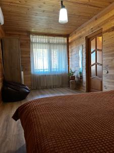 KolonshchinaРанчо, Дом для релакса в окружении леса и озёр的小木屋内一间卧室,配有一张床