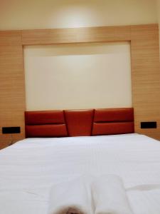 GauripurHOTEL SKYKING的一间卧室配有一张白色大床和红色床头板