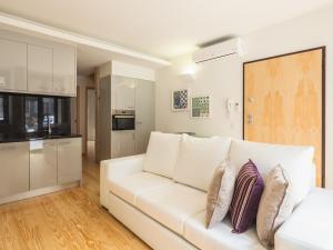 波尔图InSitu Trindade by Guestify的一间带白色沙发的客厅和一间厨房