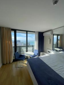 巴统Orbi Сity Sunny Apartments high floor的酒店客房带一张床、一张桌子和椅子
