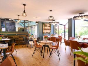 阿布维尔宜必思阿布维尔酒店的餐厅设有桌椅和窗户。