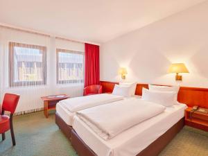 巴特迪克海姆巴特迪克海姆美居酒店的酒店客房设有一张大床和红色窗帘