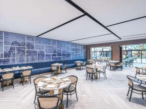 迪拜索菲特迪拜朱美拉海滩酒店的餐厅设有桌椅和一扇窗户