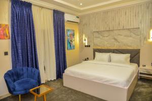 阿布贾SS3 Jabi Hotel的一间卧室配有一张床和一张蓝色椅子