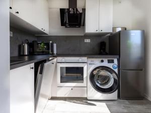 埃森# VAZ Apartments E01 Küche, TV, Netflix, ca 15 Min Messe u HBf的厨房配有洗衣机和冰箱。