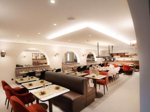 弗里堡Mercure Fribourg Centre Remparts的一间带桌椅的餐厅和一间酒吧