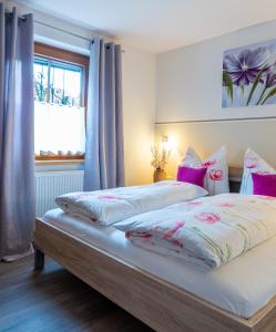利恩茨Haus Sonnengarten-Lienz的卧室配有一张带粉红色枕头的大床