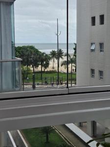 桑托斯Apartamentos na Praia do Gonzaga的从大楼的窗户可欣赏到海滩美景