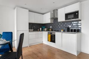 BuckinghamshireLivestay-Modern Apartments Building in Aylesbury的厨房配有白色橱柜和餐桌