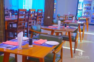 达累斯萨拉姆Nefaland Hotel的用餐室配有木桌和椅子
