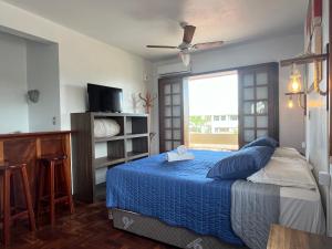 弗洛里亚诺波利斯Pousada Canajurê的一间卧室配有一张带蓝色毯子的床和窗户。