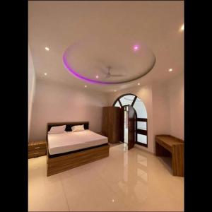 PrayagrajMauji's Villa Hotel & Guest House的一间卧室配有一张紫色天花板的床
