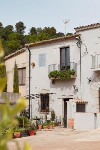 赫罗纳Can Feliu, Masia Stone House, Apartment and Ground-Floor apartment, Sant Daniel-Girona的白色房子,阳台上种有植物