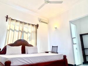 吉汶瓦Asili Nyumbani Residence的一间卧室设有一张床和一个窗口