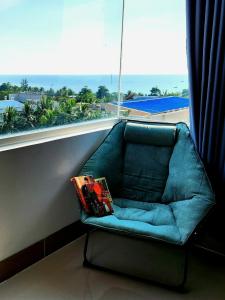 富国Mi Amor Luxury Island Apartment - 3 minutes to the beach的窗前的蓝色沙发