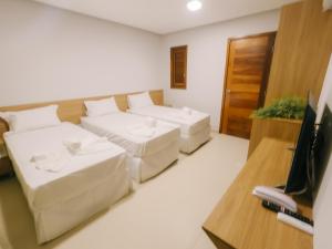 图托亚Oiti Beach Resort Tutoia的一间带两张床和电视的客厅