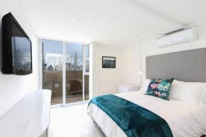开普敦Modern & Luxurious Seaside Apartment的白色的卧室设有床和大窗户