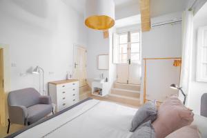 瓦莱塔Carmelita Valletta的卧室配有床、椅子和窗户。