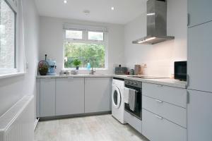 贝尔法斯特Close to City Centre Stylish and Cosy Home的白色的厨房配有洗衣机和烘干机