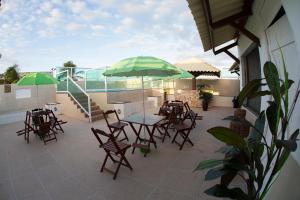 阿拉卡茹Araras Praia Hotel的一个带桌椅和遮阳伞的庭院