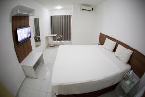 阿拉卡茹Araras Praia Hotel的酒店客房,配有床和电视