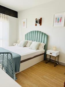 蒙蒂戈杜Sunset Lover Aparthotel Guadiana的一间卧室配有一张蓝色床头板的床