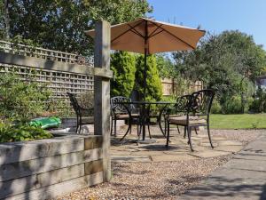 海尔舍姆Lavender Cottage的花园内桌椅和遮阳伞