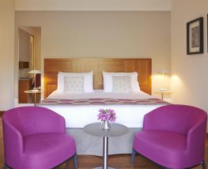贝拉吉奥贝维德雷酒店的一间卧室配有一张大床和紫色椅子