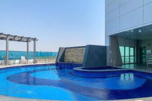 迪拜Manzil - 1BR in The Bay with Canal View nr Dubai Mall的大楼前的大型蓝色游泳池