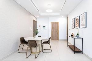 迪拜Manzil - 1BR in The Bay with Canal View nr Dubai Mall的一间配备有白色桌椅的用餐室