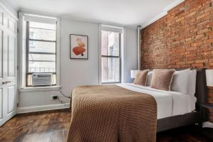 纽约West Village 2br w wd nr shopping NYC-1274的一间卧室设有一张床和砖墙