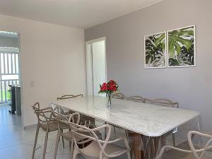 巴拉那州蓬塔尔Apartamento 1 quadra do mar的餐桌、椅子和花瓶