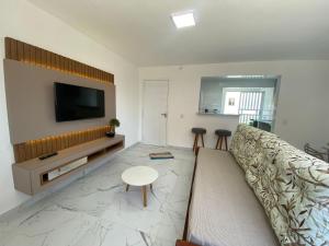 巴拉那州蓬塔尔Apartamento 1 quadra do mar的带沙发和平面电视的客厅