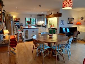 穆尔兰尼Stone fronted detached cottage just over 2 miles from Mulranny village的厨房以及带木桌和椅子的用餐室。