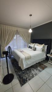 米德兰URlyfstyle Cottage @ Kikuyu waterfall的卧室设有一张白色大床和一扇窗户。