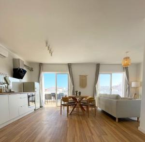 波尔蒂芒Sun Waves Beach Apartment的厨房以及带桌子和沙发的客厅。
