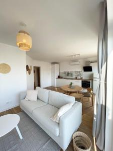 波尔蒂芒Sun Waves Beach Apartment的客厅配有白色的沙发和桌子