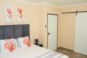马塞卢Rental Flat in Maseru的一间卧室配有带橙色和白色枕头的床