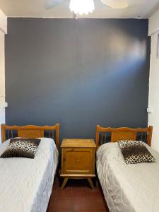 乌拉圭河畔康塞普西翁3260HOSTEL的蓝色墙壁客房的两张床