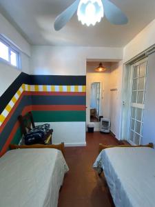 乌拉圭河畔康塞普西翁3260HOSTEL的一间卧室设有两张床和彩色的墙壁