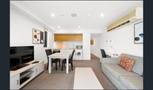 阿德莱德Hi 5 star Adelaide City Luxury Oasis的带沙发和桌子的客厅以及厨房。