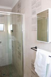 马塞卢Rental Flat in Maseru的玻璃门淋浴和毛巾