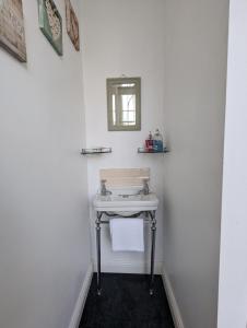 切尔滕纳姆The Dulwich的白色的浴室设有水槽和镜子