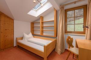 斯拉德明Appartement Berggasse by Schladming-Appartements的一间卧室配有一张床、一个窗口和一张书桌
